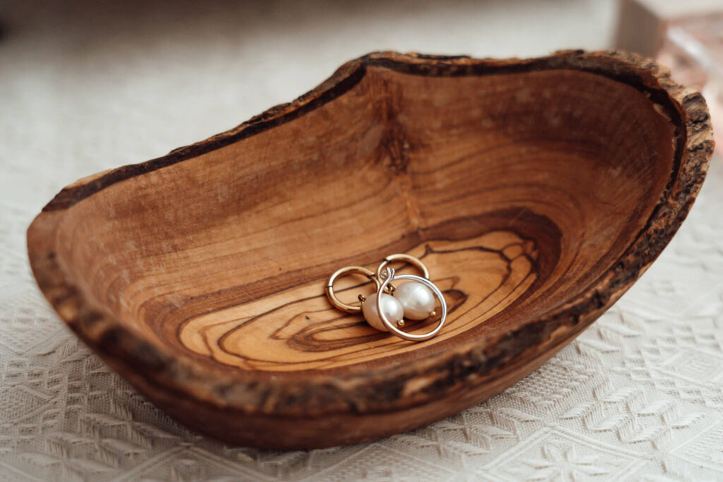 Ohrringe liegen in einem Holz-Schmuckkasten als Detailaufnahme beim Getting Ready