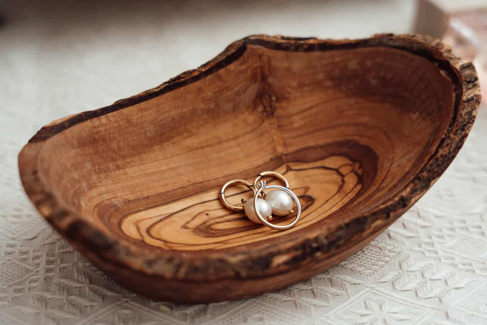 Ohrringe liegen in einem Holz-Schmuckkasten als Detailaufnahme beim Getting Ready