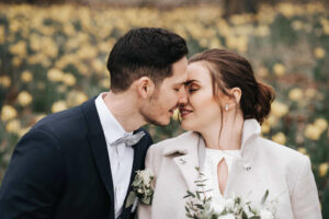 Hochzeitsfotograf aus Wolfsburg fotografiert ein küssendes Brautpaar im Blumenbeet am Schloss Richmond in Braunschweig