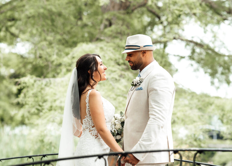 Brautpaarshooting in einem Park in Hannover: Brautpaar steht sich auf einer Brücke gegenüber und schaut sich lächelnd an