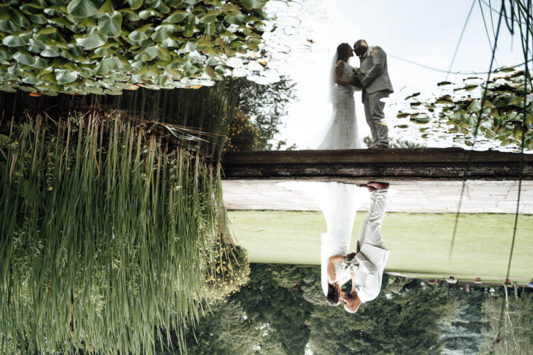 Brautpaarshooting in Hannover mit Spiegelung am Wasser, romantischer Moment in natürlicher Kulisse