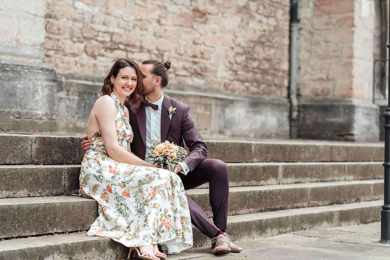 Brautpaarshooting in der Stadt Braunschweig: Brautpaar sitzt an einer Treppe, urbaner und natürlicher Moment