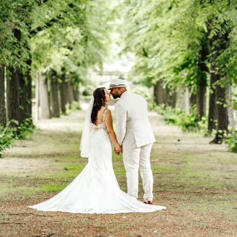 Brautpaarshooting im Stadtpark Hannover: Brautpaar hält sich an den Händen und läuft entspannt durch das Grün