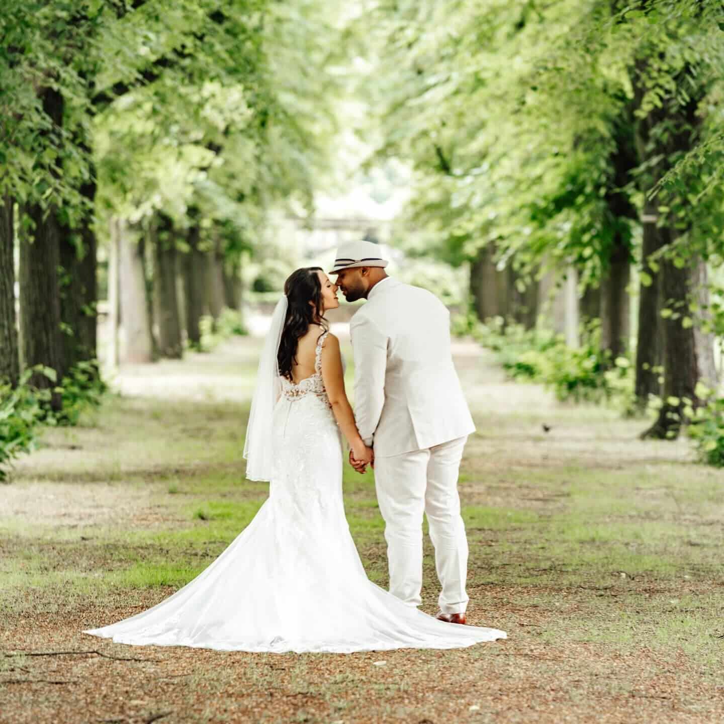 Brautpaarshooting im Stadtpark Hannover: Brautpaar hält sich an den Händen und läuft entspannt durch das Grün
