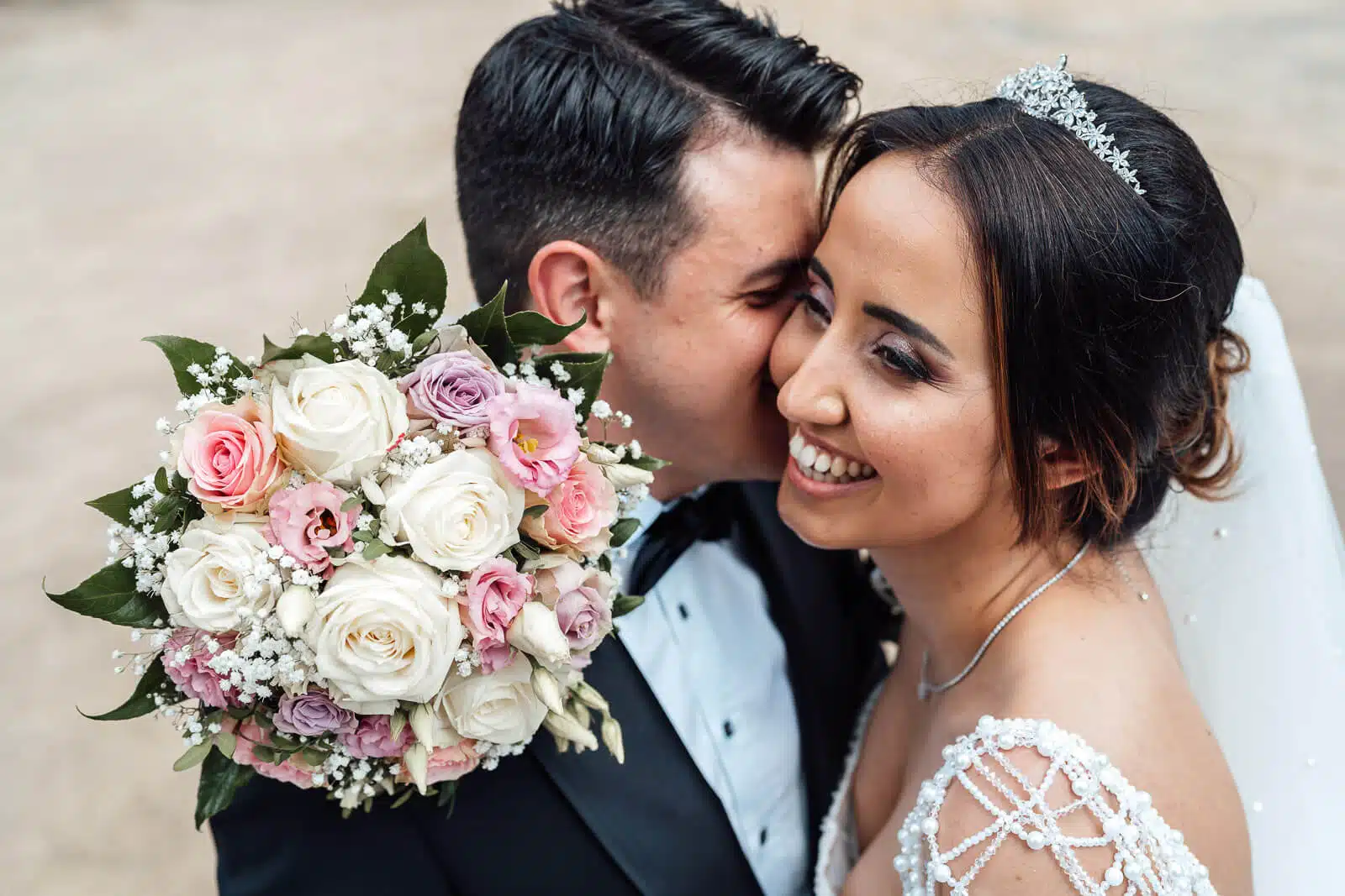 Bräutigam flüstert Braut etwas ins Ohr, sie lächelt glücklich – festgehalten bei einer Hochzeit in Weyhausen