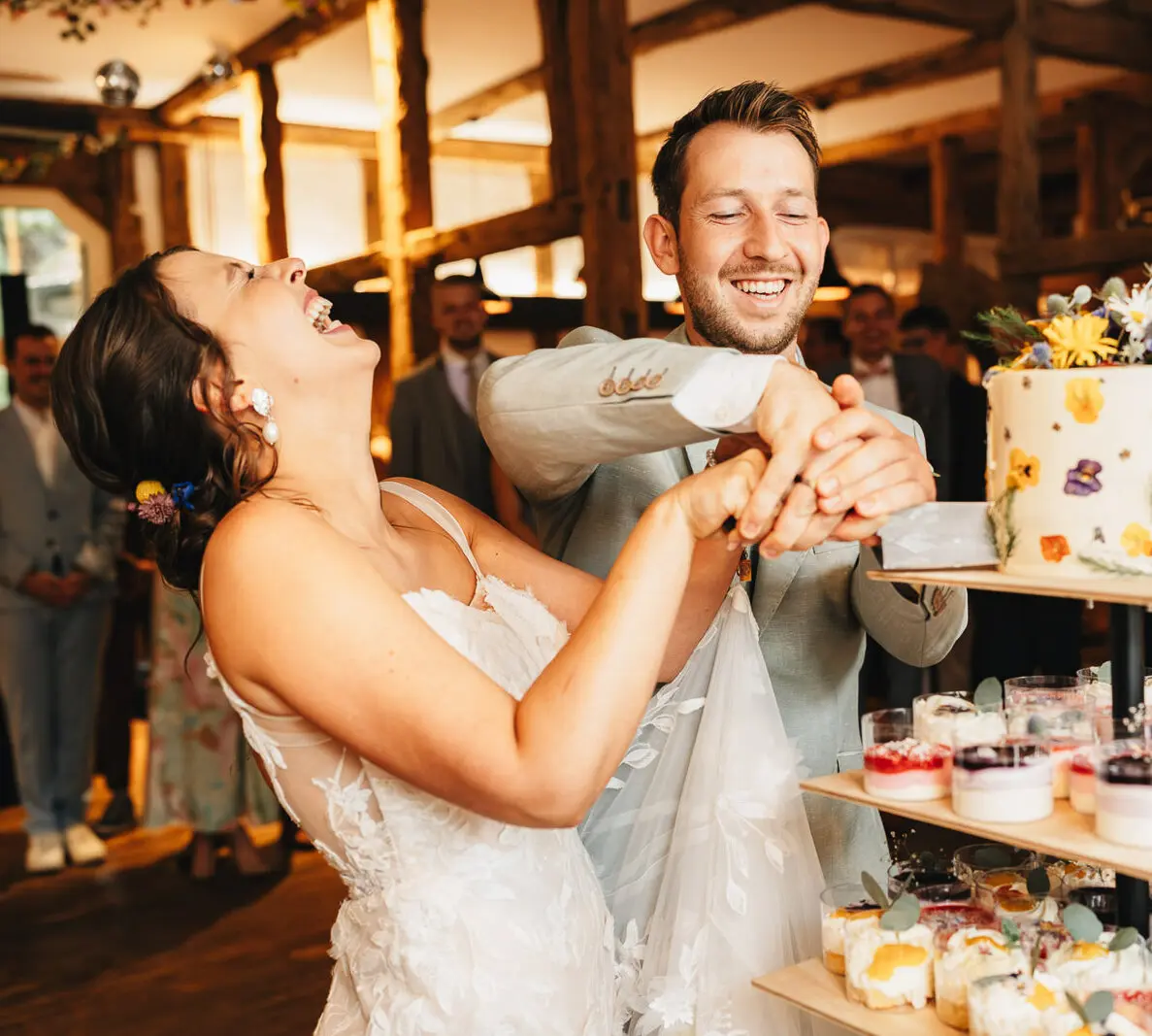 Hochzeitsfotograf Wolfsburg – Braut und Bräutigam lachen beim gemeinsamen Anschneiden der Hochzeitstorte im Festwerk