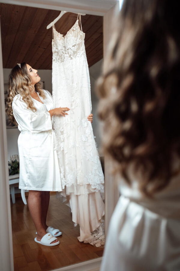 Braut beim Getting Ready blickt auf ihr Kleid in Weyhausen