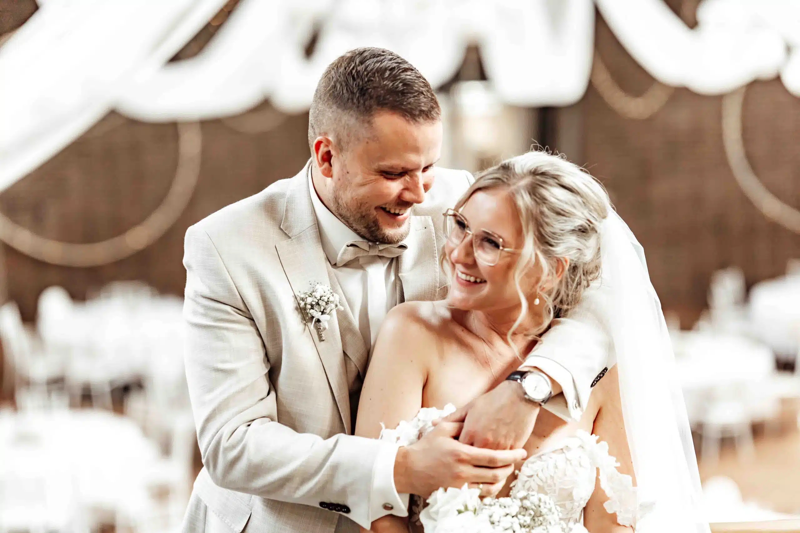 Hochzeitsfotograf Gifhorn hält ein Brautpaar fest, das sich eng umarmt und glücklich auf einer Wiese steht